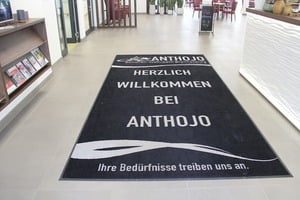 Eingangsbereich mit Teppich: "Willkommen bei Anthojo"